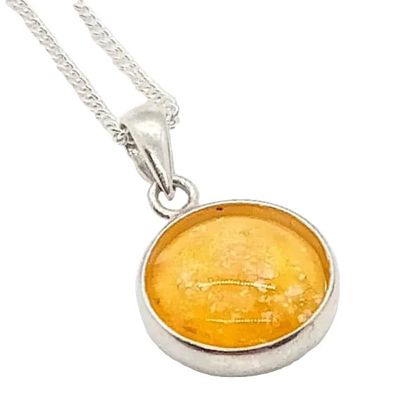 A sterling silver pendant memorial necklace with an amber-colored glass charm, set on a white background .