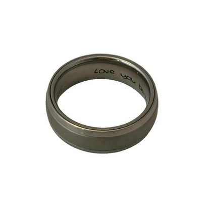 grey ashes dome ring with silver edges and hand written love you engraving on the inside of the ring on a white background