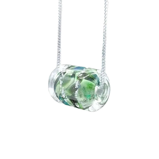 Necklace with a green and clear glass pendant on a plain background