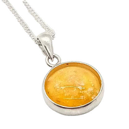 A sterling silver pendant memorial necklace with an amber-colored glass charm, set on a white background .