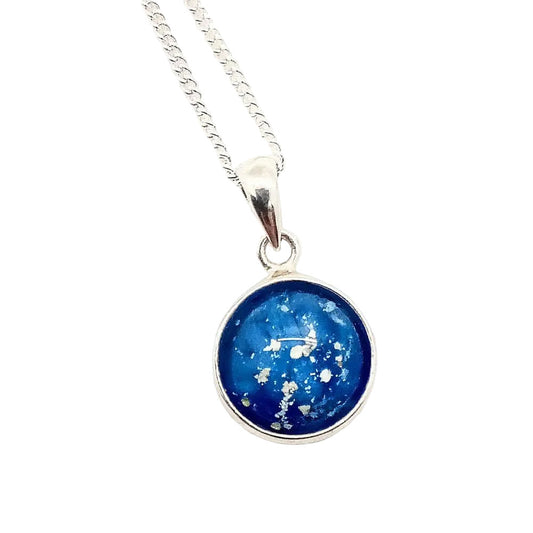 A sterling silver pendant memorial necklace with a blue-colored glass charm, set on a white background.