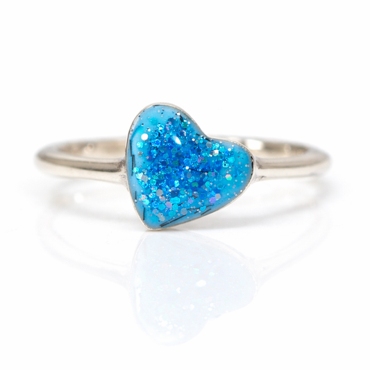 Silver slim ring band with Aqua Blue glittery heart-shaped stone on a white background
