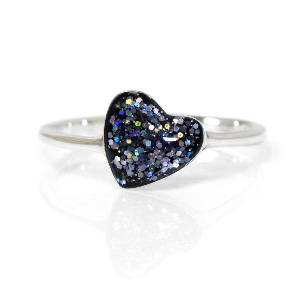 Silver slim ring band with black glittery heart-shaped stone on a white background