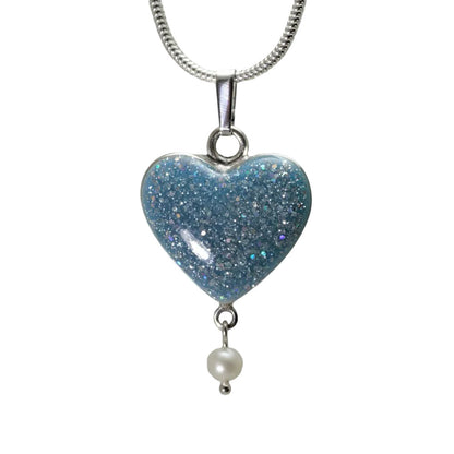 Aqua colour heart-shaped ashes pendant with a pearl drop on a silver snake chain, with white background