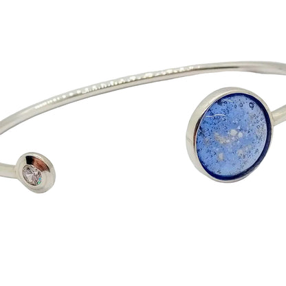 Silver ashes bracelet with blue circular accent on a white background
